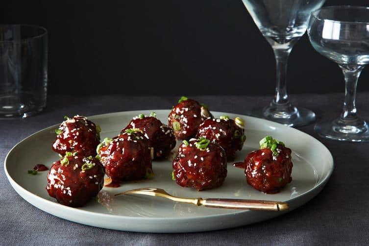 Korean meatballs on gray plate with gold fork. 