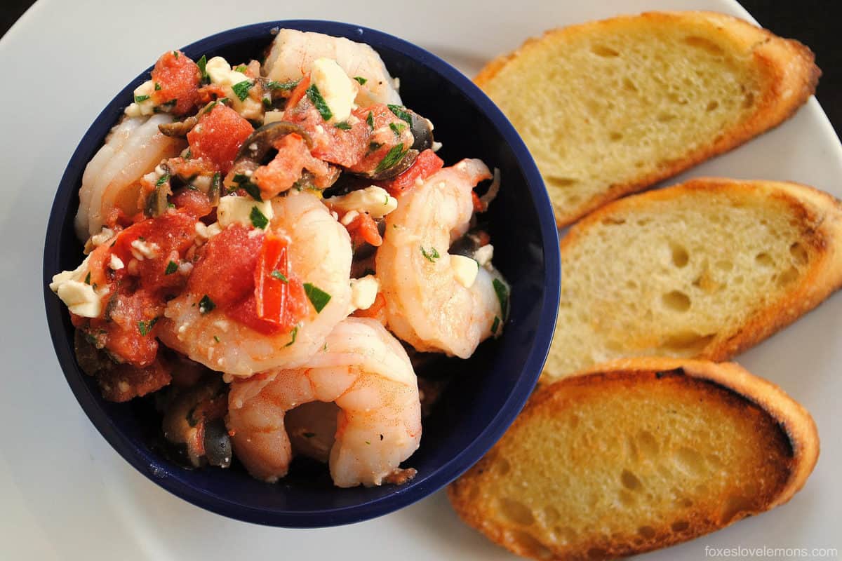 Greek Shrimp Bruschetta - Perfect for a party! Sauteed shrimp with olives, tomato, feta and capers. Serve with crunchy bruschetta. | foxeslovelemons.com