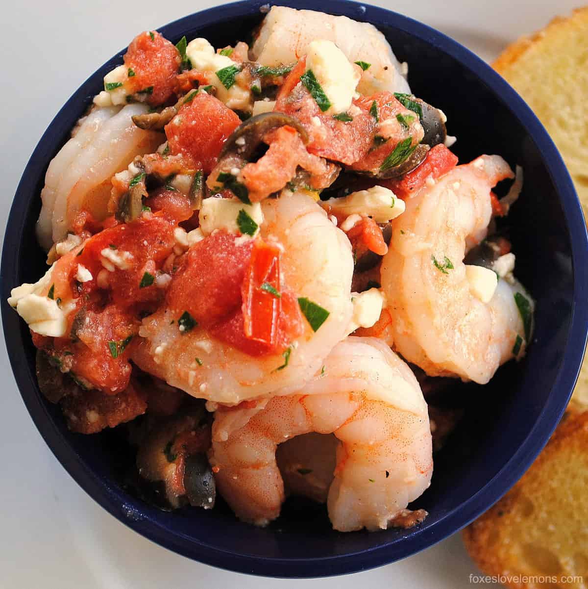 Greek Shrimp Bruschetta - Perfect for a party! Sauteed shrimp with olives, tomato, feta and capers. Serve with crunchy bruschetta. | foxeslovelemons.com