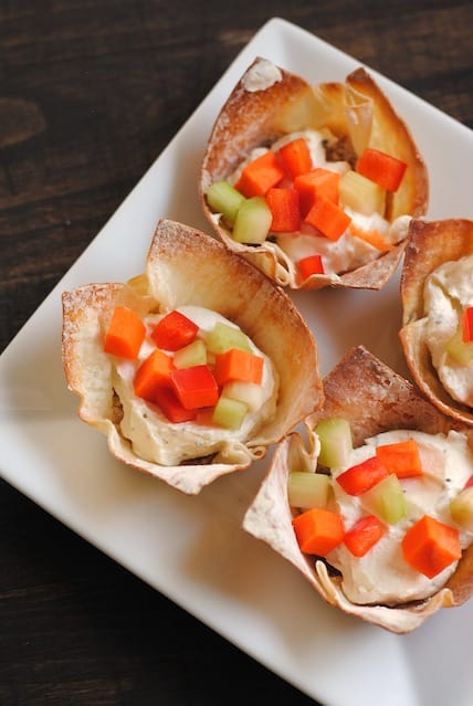 Overhead photo of crispy wonton cups filled with ranch dip and chopped fresh vegetables.