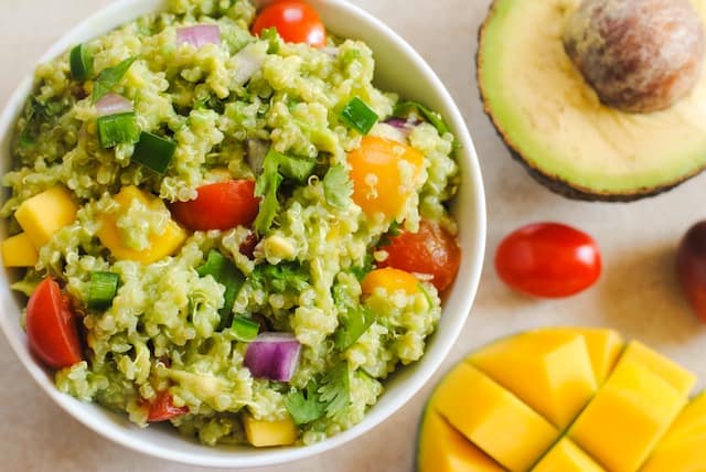 Guacamole Quinoa with Mango - all of the ingredients of guacamole, combined with quinoa and a little mango, for a tasty, healthy side dish! Serve warm or cold. | foxeslovelemons.com