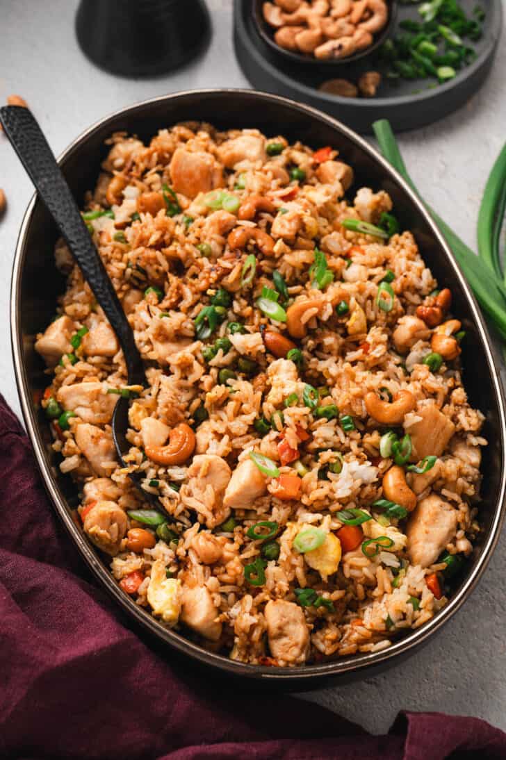 A shallow dark dish filled with homemade chicken fried rice.