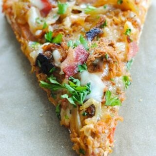 Loaded slice of pizza on tan background.