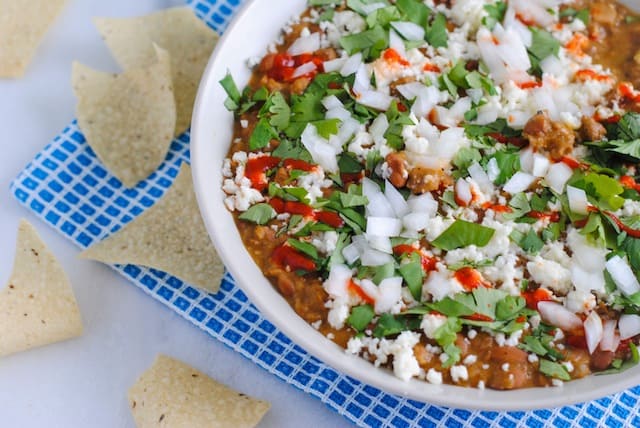 5 Ingredient Bean & Chorizo Dip - Chorizo, pinto beans, tomatillo salsa, lime juice and sour cream combine to make a game day dip the whole crowd will love! | foxeslovelemons.com
