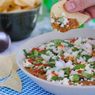 5 Ingredient Bean & Chorizo Dip - Chorizo, pinto beans, tomatillo salsa, lime juice and sour cream combine to make a game day dip the whole crowd will love! | foxeslovelemons.com