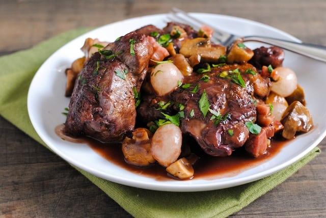 Classic Coq au Vin - Chicken, pancetta, mushrooms and pearl onions braised in red wine. Comfort food at it's finest. Perfect for a dinner party! | foxeslovelemons.com