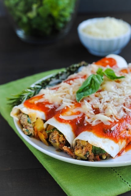 Italian Enchiladas - A tasty casserole (with hidden veggies!) the whole family will enjoy! Ground beef, Italian sausage, pepperoni, artichokes, spinach, mushrooms and ricotta cheese rolled up in flour tortillas, topped with marinara and mozzarella. | foxeslovelemons.com