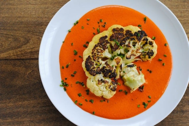 Seared Cauliflower Steaks with Red Pepper-Walnut Sauce - A Meatless Monday dish that still eats like a steak. Big slices of cauliflower are seared in a cast iron skillet then finished in the oven, for a crunchy golden brown crust on the outside. Served over a ladle of Spanish-inspired pureed red pepper and walnut sauce. | foxeslovelemons.com