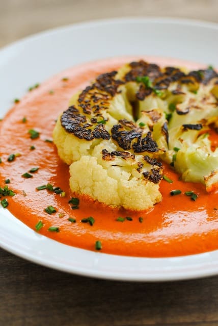 Seared Cauliflower Steaks with Red Pepper-Walnut Sauce - A Meatless Monday dish that still eats like a steak. Big slices of cauliflower are seared in a cast iron skillet then finished in the oven, for a crunchy golden brown crust on the outside. Served over a ladle of Spanish-inspired pureed red pepper and walnut sauce. | foxeslovelemons.com