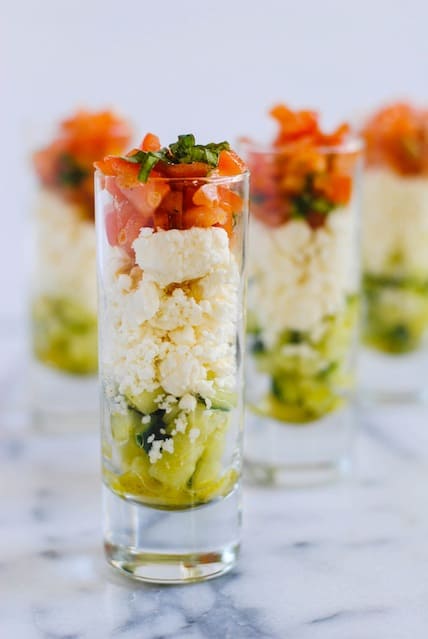 Feta Salad Shooters - layers of crunchy cucumber, tangy feta cheese, and fresh tomato and basil. A perfect, simple party bite for the summer! | foxeslovelemons.com