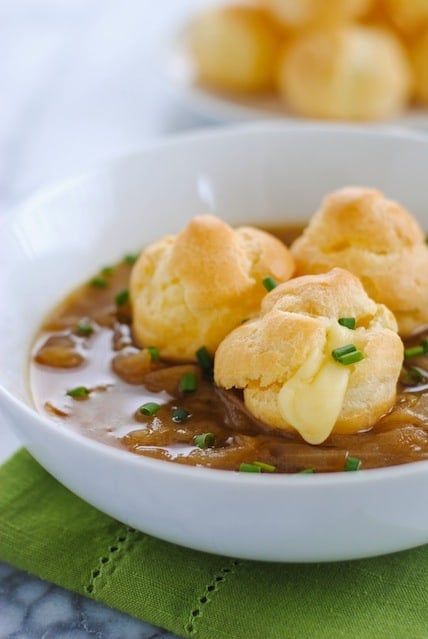 French Onion Soup with Cheese-Filled Gougeres - Classic French Onion Soup topped with little cream puffs filled with gloriously melty cheese. | foxeslovelemons.com
