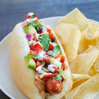 Bacon-Wrapped Sonoran Hot Dogs - Hot dogs wrapped in bacon, tucked into buns filled with beans, avocado, lime sour cream and other Mexican-inspired toppings! | foxeslovelemons.com