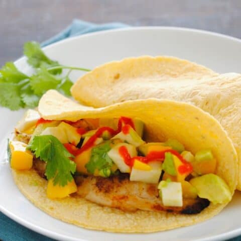 Grilled Fish Tacos with Summer Salsa - Cumin-rubbed grilled tilapia topped with avocado, mango, jicama and cilantro. | foxeslovelemons.com