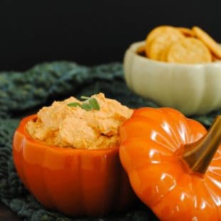 Light orange creamy dip in a ceramic pumpkin.