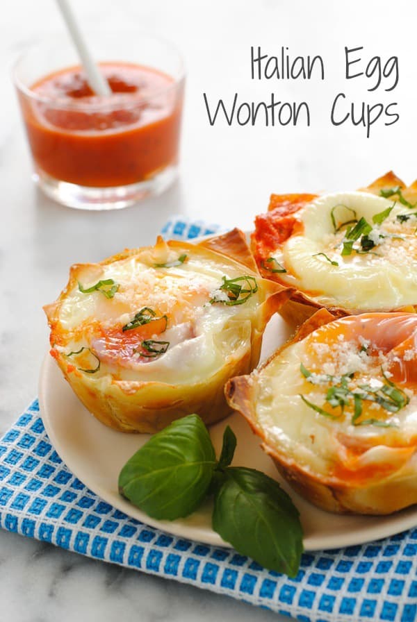 Italian Egg Wonton Cups - A cute, delicious way to serve eggs to a crowd at brunch! Crispy wonton cups filled with marinara sauce and eggs, topped with Parmesan cheese and basil. | foxeslovelemons.com