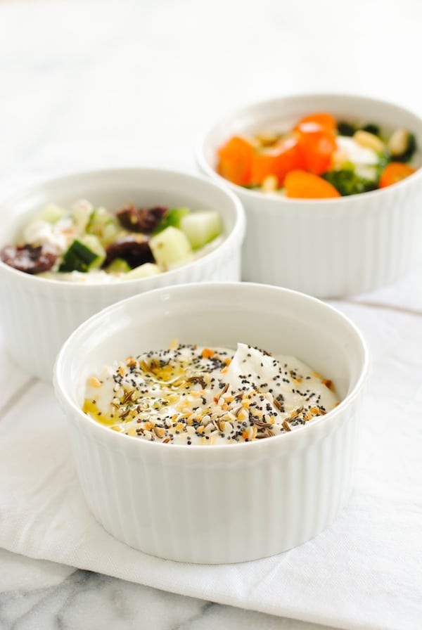 Closeup of ramekins of savory yogurt recipes with various toppings.