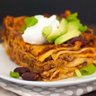 Gluten-Free Chili Lasagna - No matter your reason for skipping gluten, this casserole doesn't skip any flavor! Layers of pasta, hearty beef and bean chili, and Colby Jack cheese, topped with Greek yogurt and avocado! | foxeslovelemons.com