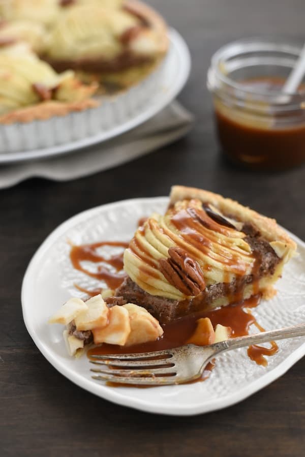 Apple & Pecan Tart with Bourbon Caramel Sauce - A flaky tart crust layered with homemade maple-pecan butter and apples, then drizzled with decadent bourbon caramel sauce! | foxeslovelemons.con