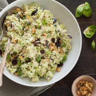 Fruit & Nut Brussels Sprout Slaw - A healthful and tasty coleslaw made with shredded brussels sprouts, dried cranberries and walnuts, tossed with a tangy yogurt-orange dressing! | foxeslovelemons.com