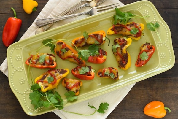 Black Bean Stuffed Mini Pepper Bites - A protein-packed snack, or fun party appetizer! Mini bell peppers stuffed with refried black beans and topped with cheese. | foxeslovelemons.com