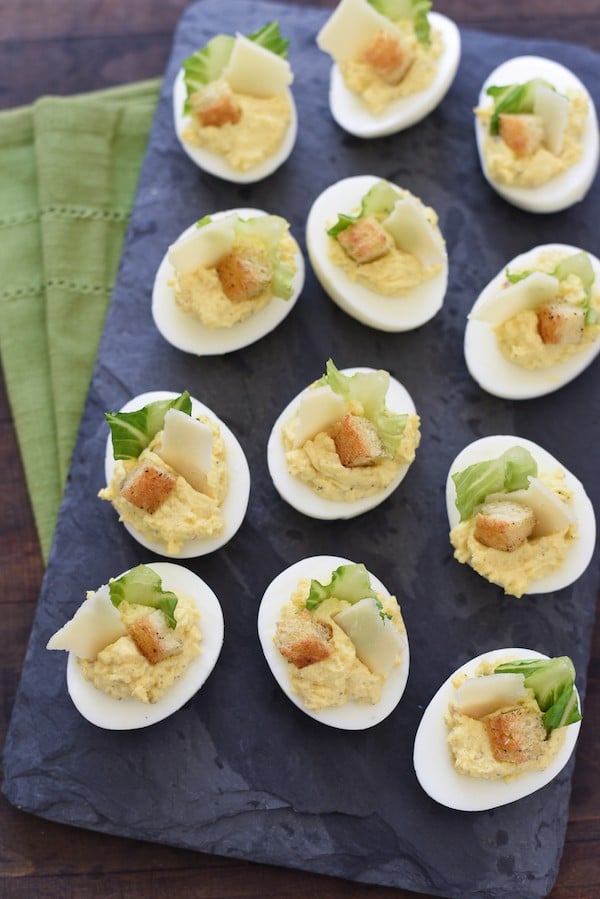 Caesar Salad Deviled Eggs - For this fun take on deviled eggs, egg yolks are mixed with classic Caesar salad flavors and Greek yogurt. If desired, garnish with lettuce, shaved Parmesan cheese and a crouton! | foxeslovelemons.com