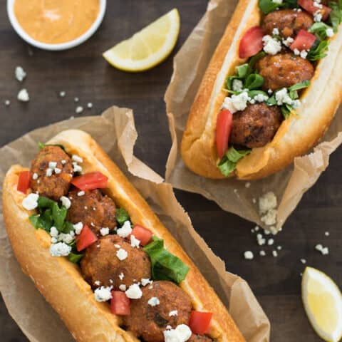 Buffalo Falafel Subs - Fried chickepea fritters are tossed in buffalo sauce then piled into subs with buffalo-flavored hummus, lettuce, tomato and blue cheese! | foxeslovelemons.com