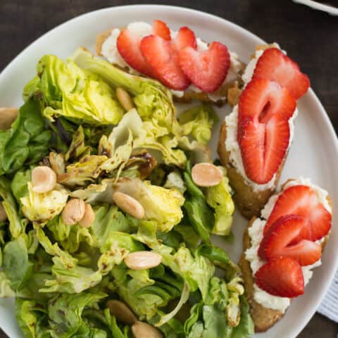 Summer Salad with Stawberry-Ricotta Toast - Stay cool this summer with this refreshing butter lettuce salad tossed with balsamic vinaigrette and almonds. Serve with crostini topped with creamy ricotta cheese and juicy sliced strawberries. | foxeslovelemons.com