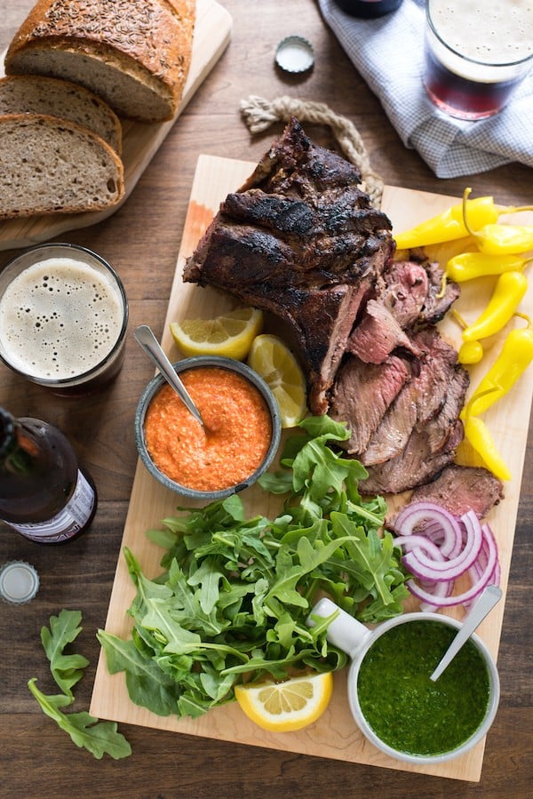 Grilled Lamb Sandwich Platter - Change up your grilling game with a boneless leg of lamb! It cooks in the same amount of time as a thick steak, and has a rich delicious flavor. Pile sandwich fixings, zesty feta spread, chimichurri and rye bread onto a big board, and dinner is served! | foxeslovelemons.com