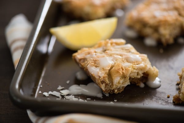 Lemon Coconut Dream Bars - A tropical treat that will whisk you away to an island! Graham cracker crust is topped with a lemon-infused coconut and almond topping, and a lemon glaze. | foxeslovelemons.com