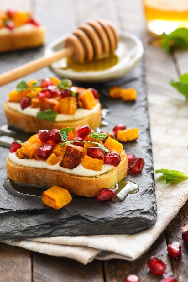 Butternut Squash & Pomegranate Crostini with Whipped Feta and Honey - This autumn appetizer is the perfect balance of sweet and savory. Set these out at your next party and watch them disappear! | foxeslovelemons.com