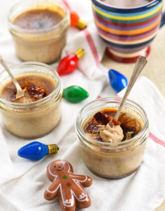 Small mason jars of gingerbread creme brulee with christmas decorations.