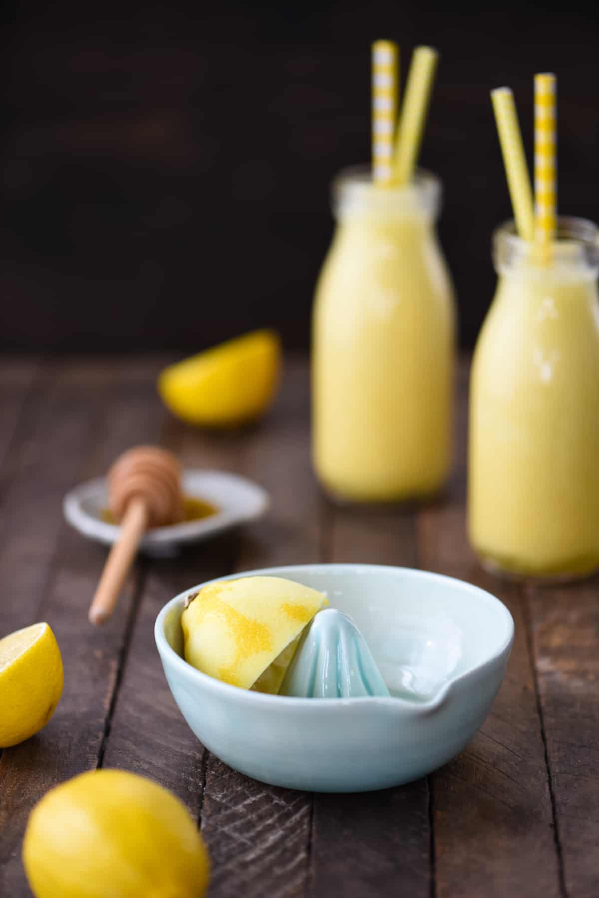 A small light blue ceramic lemon juicer bowl with a lemon half in it.