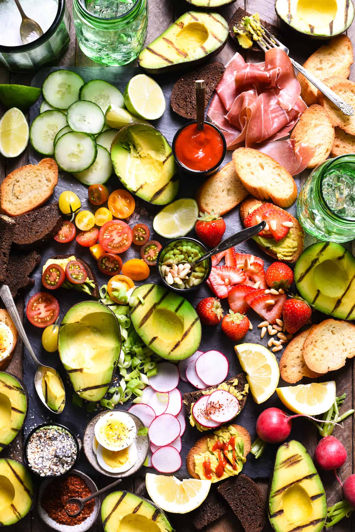 Grilled Avocado Crostini Board - A fun party idea! Pile a bunch of fresh toppings onto a big platter, and let your guests assemble their own grilled avocado crostini! | foxeslovelemons.com