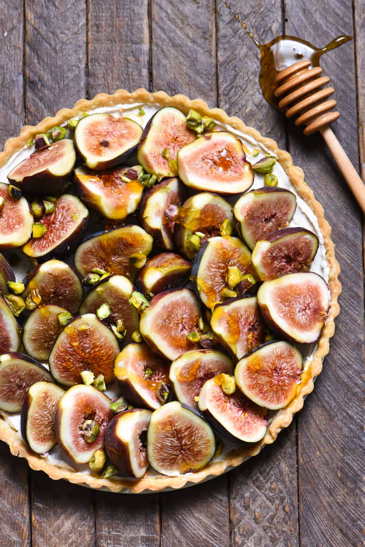Fig & Spiced Goat Cheese Tart - A "dessert" for all the cheese lovers out there. Ripe figs are piled into a flaky crust on top of sweet and savory spiced goat cheese, then topped with honey and pistachios. | foxeslovelemons.com