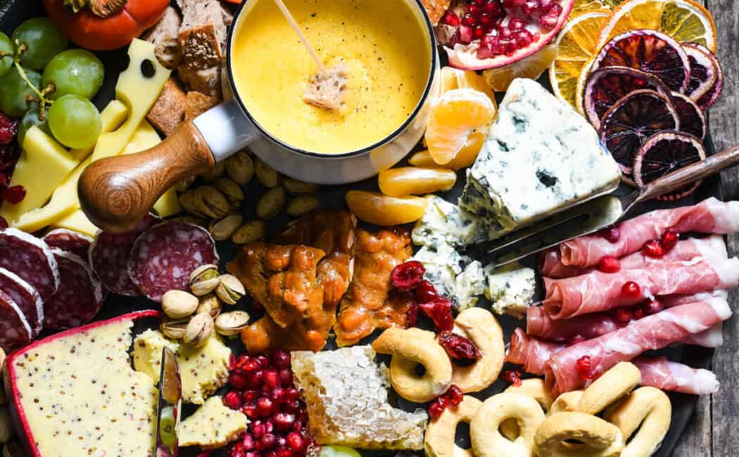 Winter Cheese Board with German Beer Cheese Fondue - Celebrate the season with this big, beautiful platter of cheese, charcuterie, bread, seasonal fruits and sweet treats. | foxeslovelemons.com