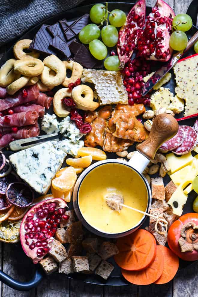 Winter Cheese Board with German Beer Cheese Fondue - Celebrate the season with this big, beautiful platter of cheese, charcuterie, bread, seasonal fruits and sweet treats. | foxeslovelemons.com