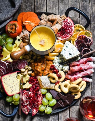 Winter Cheese Board with German Beer Cheese Fondue - Celebrate the season with this big, beautiful platter of cheese, charcuterie, bread, seasonal fruits and sweet treats. | foxeslovelemons.com