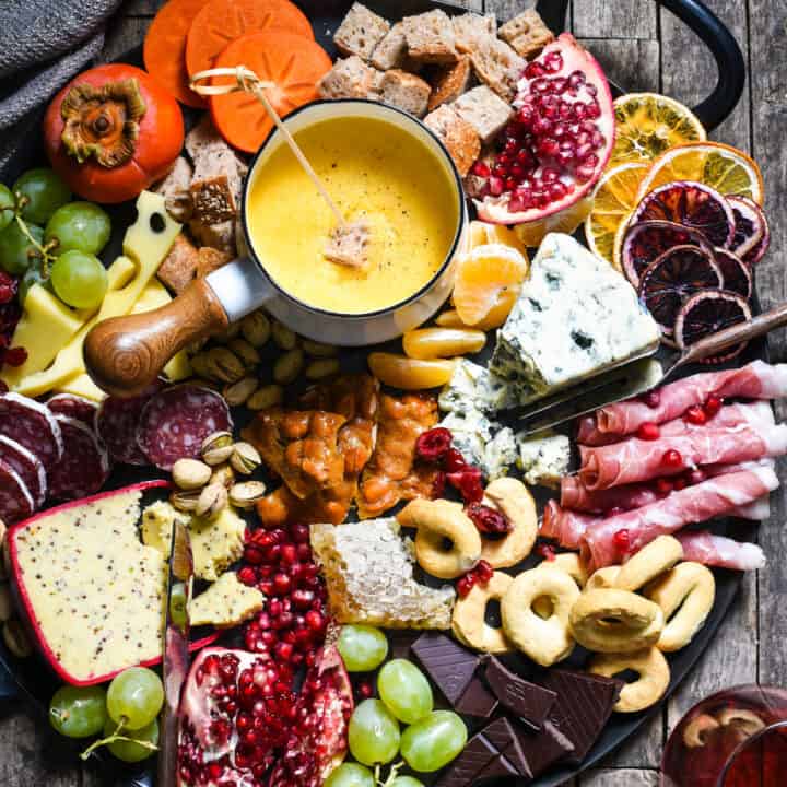 Winter Cheese Board with German Beer Cheese Fondue - Celebrate the season with this big, beautiful platter of cheese, charcuterie, bread, seasonal fruits and sweet treats. | foxeslovelemons.com
