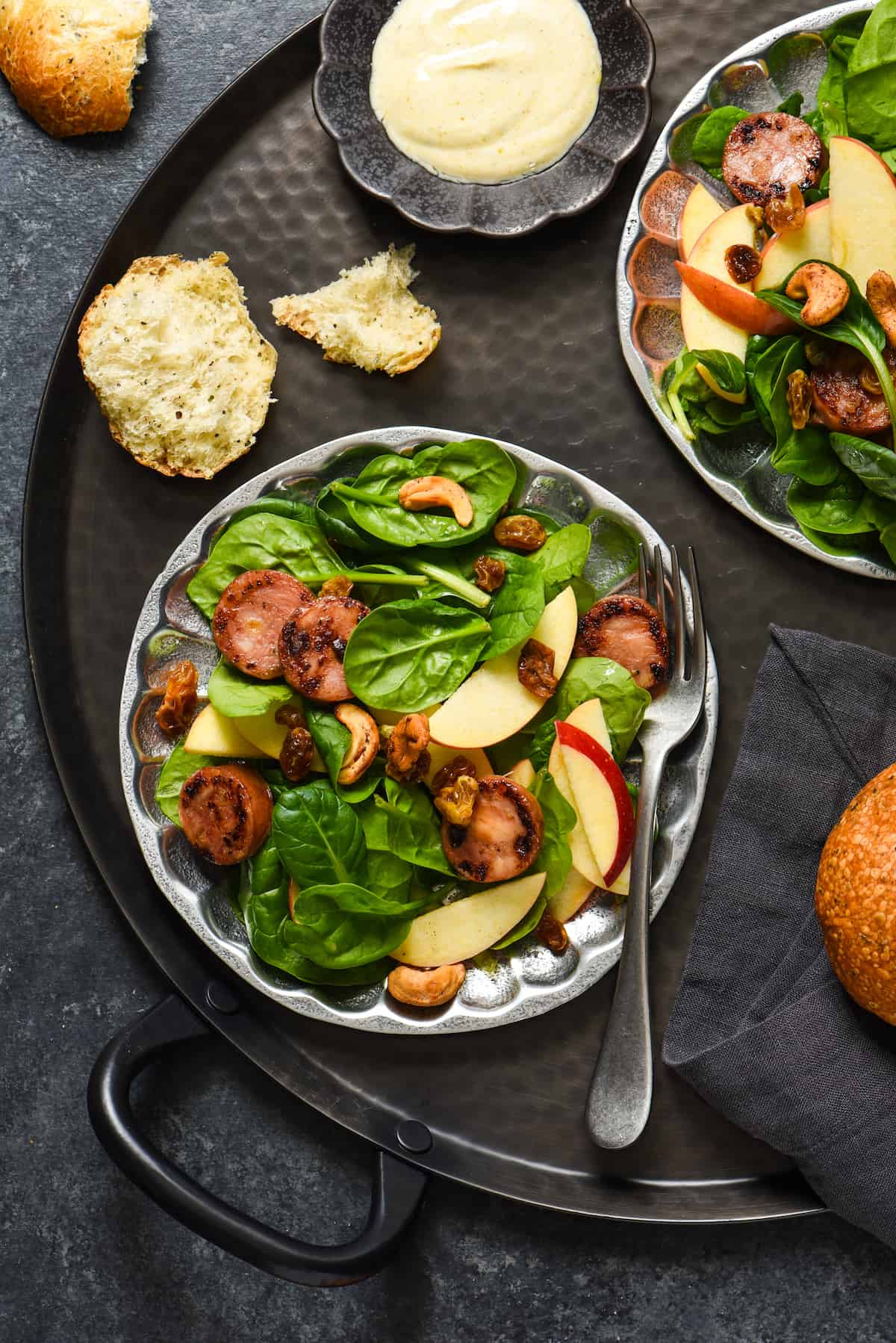Apple Sausage Salad with Curry Yogurt Dressing - Chances are, you probably have most of the ingredients for this fresh and healthy meal in your kitchen right now. Spinach, sausage, apples, raisins and spiced cashews are served with an easy curry yogurt dressing. | foxeslovelemons.com