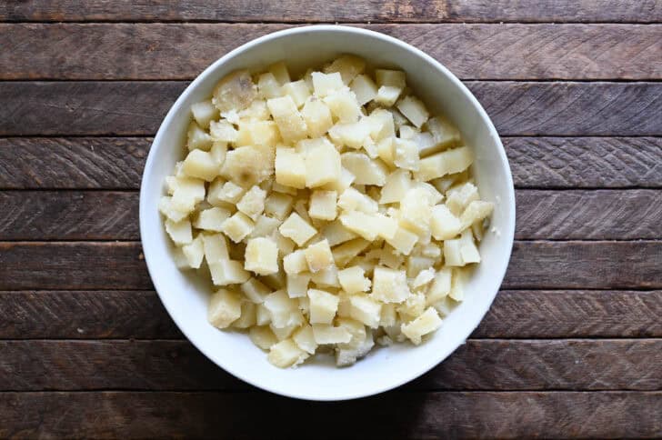 Chopped potatoes in a white bowl.