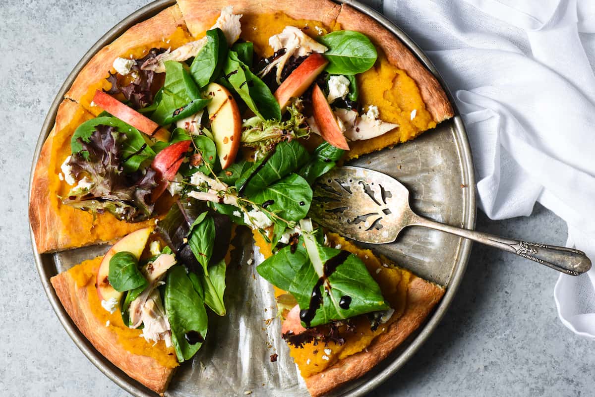 This Fall Harvest Salad Pizza celebrates all the best fresh autumn produce. Use a roasted butternut squash and maple syrup purée as the "sauce" and top with a heaping helping of salad with chicken, cheese and apples! | foxeslovelemons.com