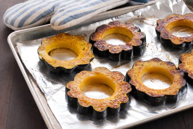 Roasted rings of acorn squash on baking pan.