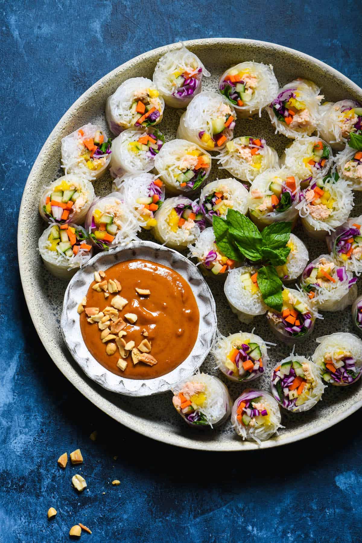 Serve the rainbow with these Salmon Fresh Rolls with Spicy Peanut Sauce. Perfect as a bright party appetizer or healthful dinner, be a "home chef" and make this takeout-inspired recipe at home! | foxeslovelemons.com