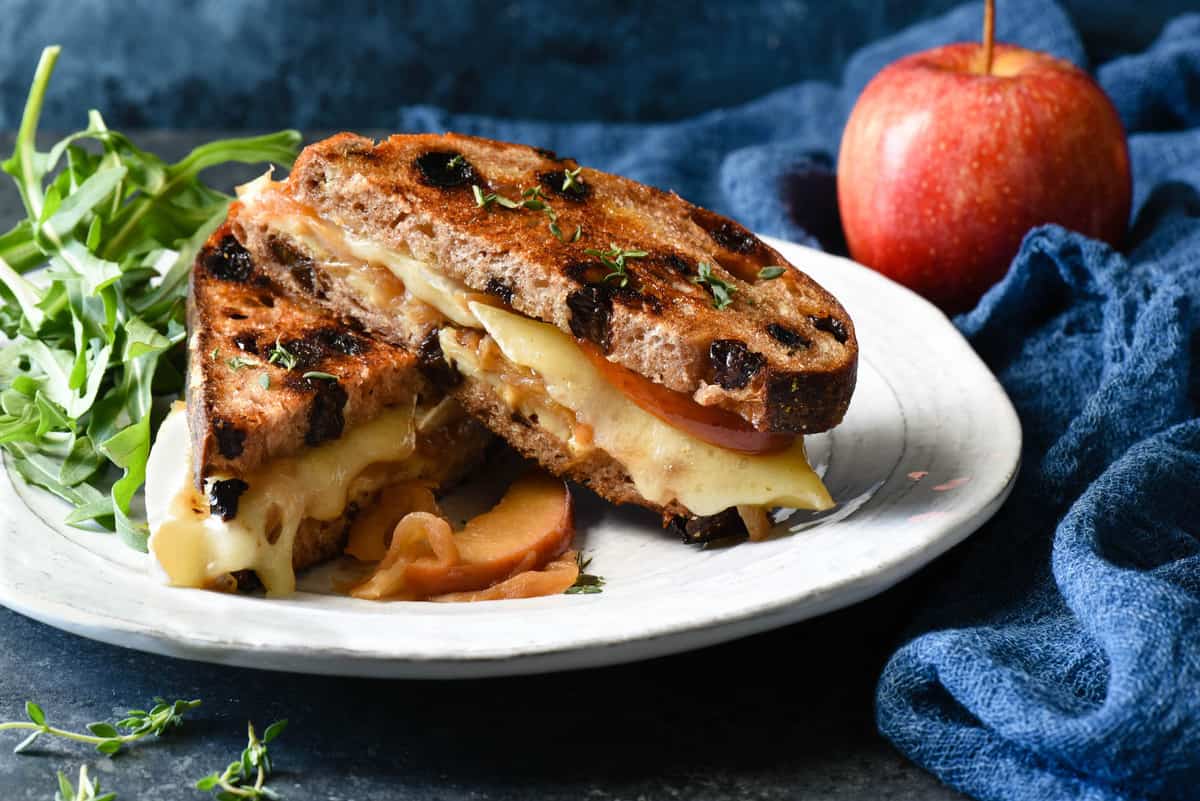 This Apple Grilled Cheese is an irresistible combination of sautéed apples, sweet caramelized onions, brie and white cheddar cheeses, Dijon mustard and walnuts. It's the best toasted sandwich you've ever made at home! | foxeslovelemons.com