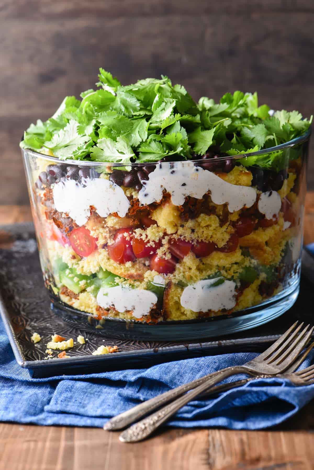 Having a backyard barbecue or going to a potluck? This Layered Southwestern Cornbread Salad can be made in advance and served cold. With the layers of colors and flavors, it's certain to stand out on the buffet table. | foxeslovelemons.com