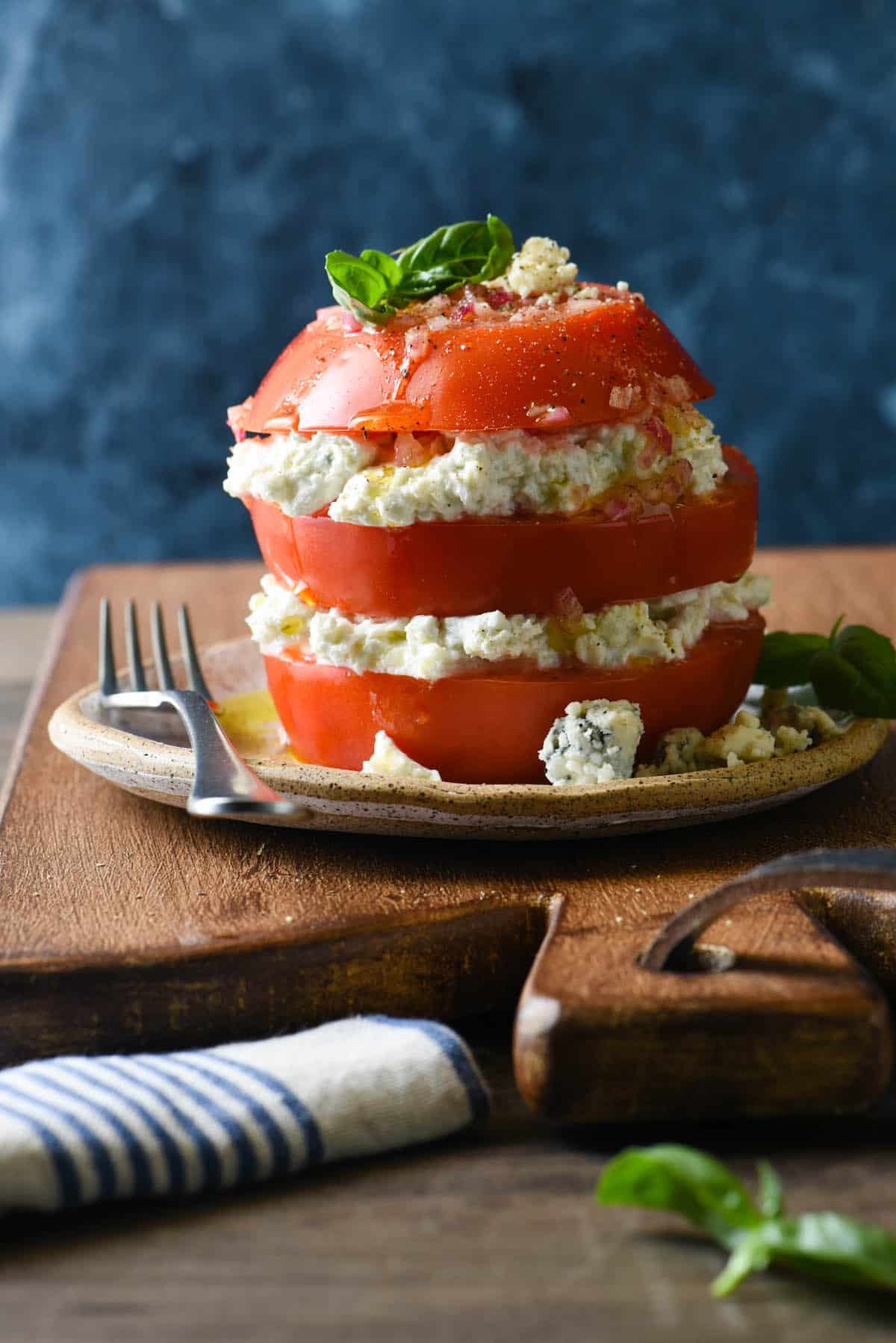 Take fresh summer tomatoes to the next level with this Tomato & Blue Cheese Salad Stack. Juicy sliced tomatoes are layered with creamy blue cheese spread and then drizzled with homemade shallot vinaigrette. | foxeslovelemons.com