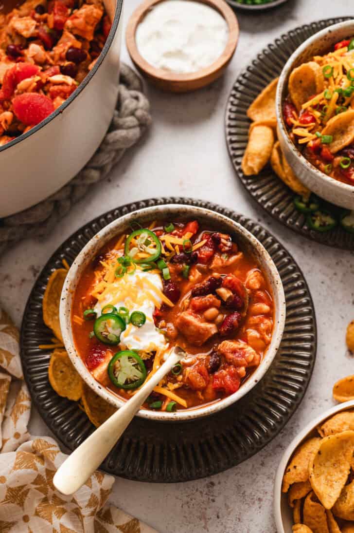 A bowl of a recipe for turkey chili with a spoon scooping some out.