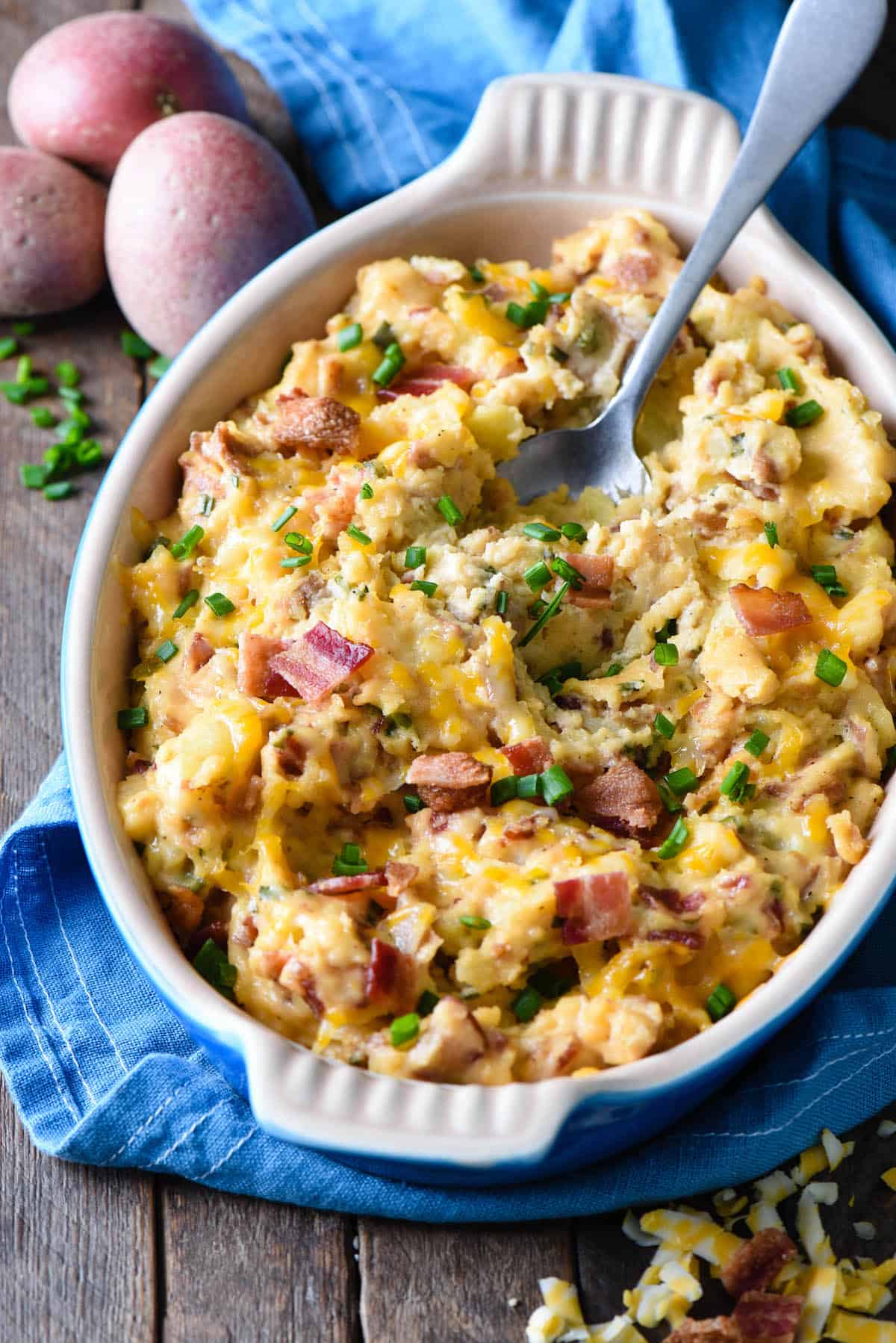 This Twice Baked Potato Casserole recipe is a perfect holiday side dish, but easy enough to make anytime. Smashed potatoes are mixed with cheese and bacon for a comforting and delicious casserole. | foxeslovelemons.com