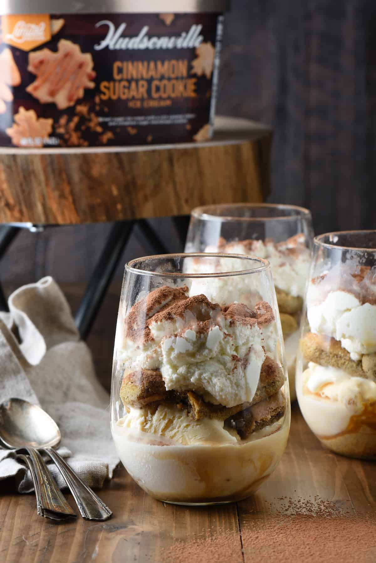 Tiramisiu trifles in stemless wine glasses, with Hudsonville Cinnamon Sugar Cookie ice cream carton on stand in background.