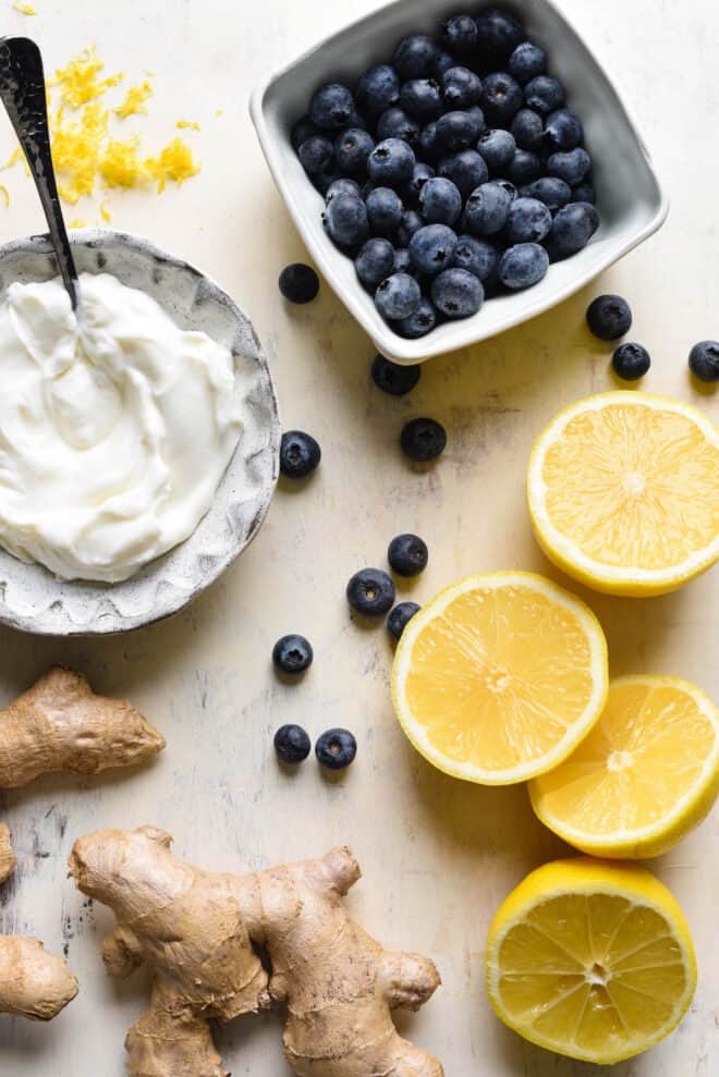 Overhead photo of ingredients including blueberries, yogurt, lemons, ginger root, lemon zest.